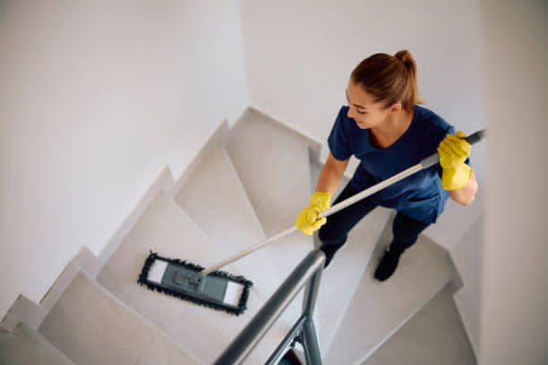 A cleaner mopping a staircase